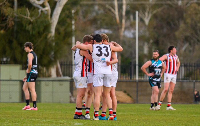 Ainslie players embracing each other on the field