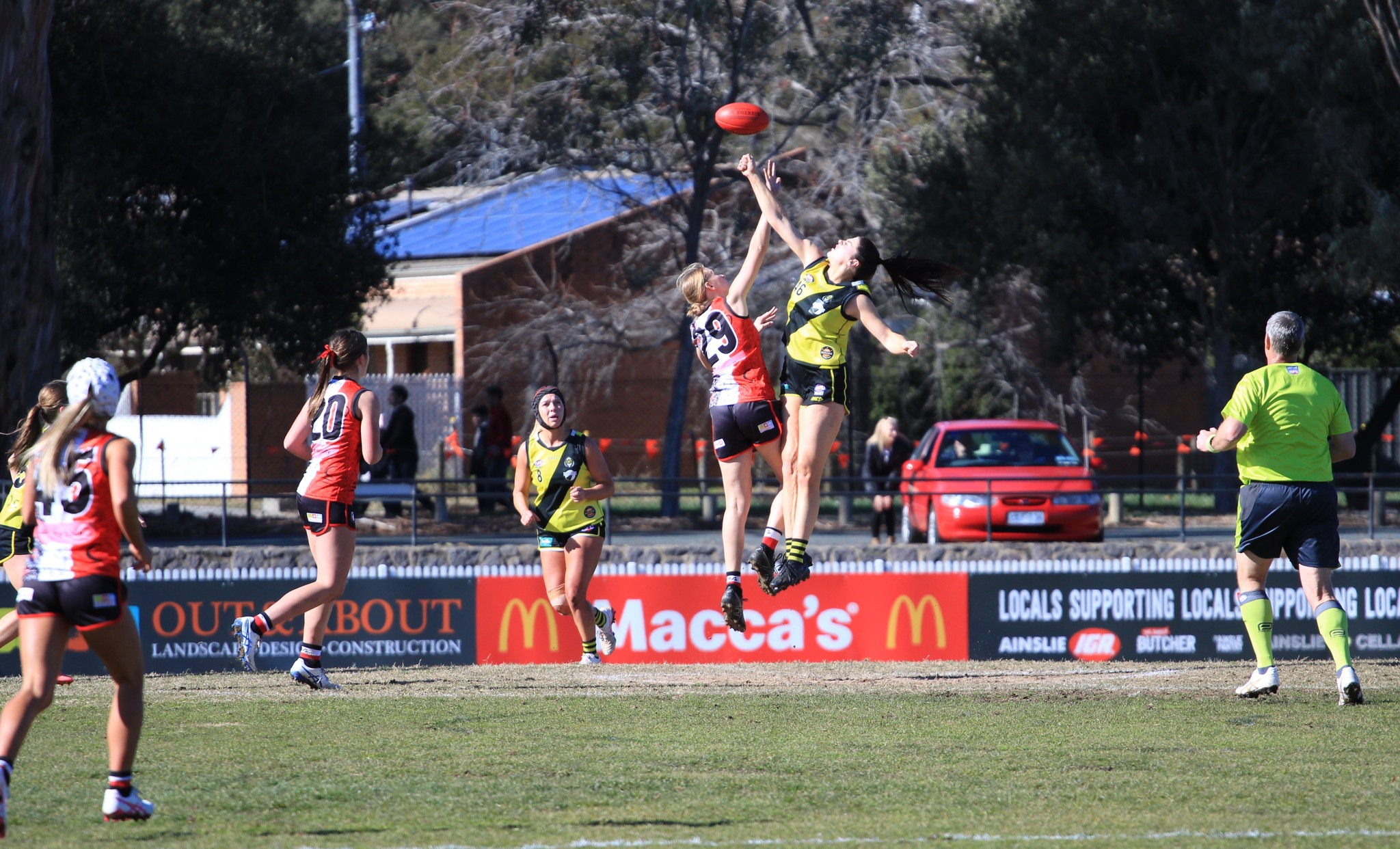 Indigenous Round jump Two AFL players, one Ainsle, one Queanbeyan. Both Jumping towards football.