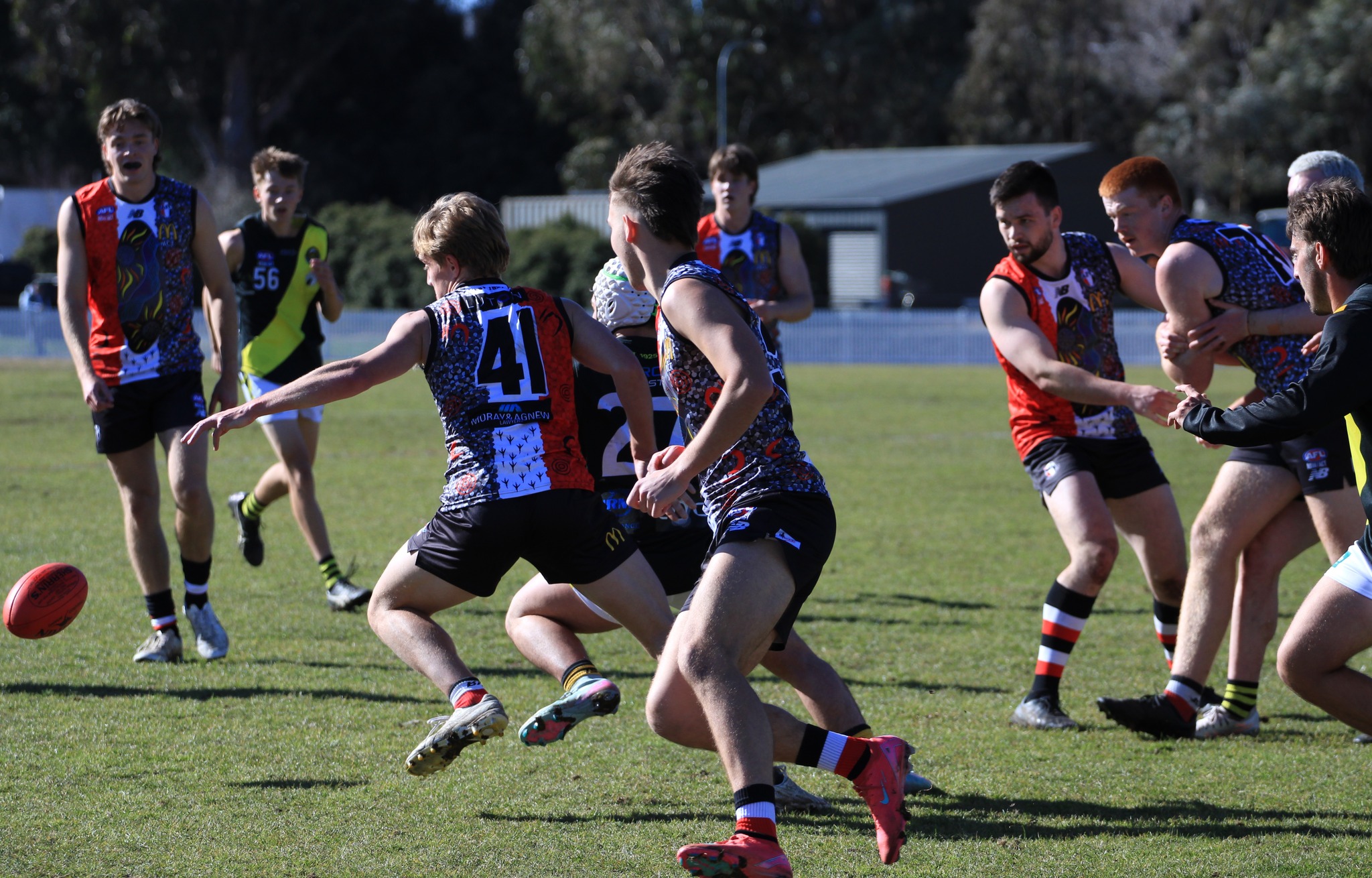 Indigenous round Ainslie group Various Ainslie AFL players running across the field
